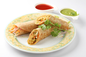 Indian Frankie Veg chapati Wrap / Kathi Roll, served in a plate with sauce & mint chutney. selective focus