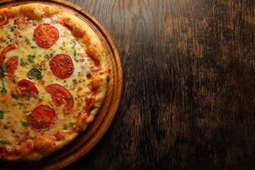 Pizza with tomatos, cheese and ham on a dark background. Italian pizza
