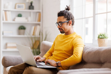 Black male freelancer working at laptop at home
