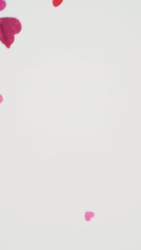 Lovely Paper Hearts - Beautiful paper hearts against a white background - vertical video - slow-mo - seamless loop 
