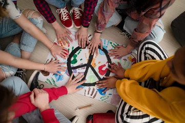 Fotobehang Top view of students making a poster of peace sign at school. © Halfpoint