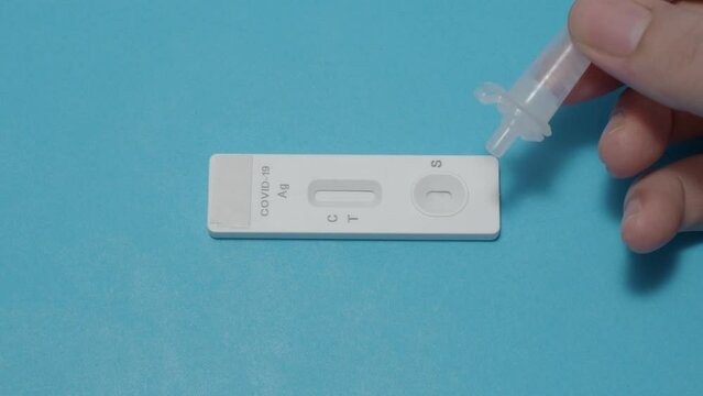 Hand holding sample tube and drops in the test device of covid 19 antigen self test. Antigen test kit for detection of coronavirus infection. Rapid antigen test. Coronavirus diagnosis. Medical device.