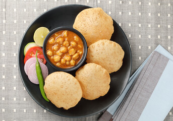 Puri and Chole traditional Indian food 
Indian dish spicy Chick Peas curry also known as Chola/Chana Masala or commonly Chole, served served with fried puri or poori  