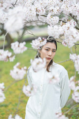 Naklejka premium 満開の桜の花と爽やかな女性
