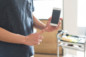 スマートフォンを持った男性美容師