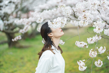 満開の桜の花と爽やかな女性