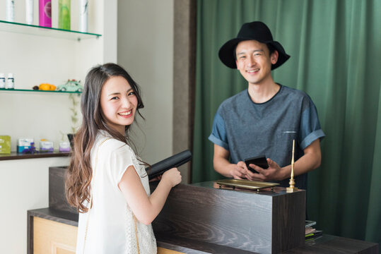 会計をする男性美容師と女性客