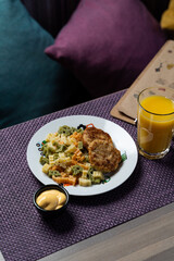 Colorful and funny pasta with two small chicken cutlets, high angle view for a menu