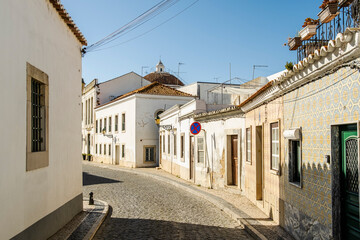 Narrow street with whitewashed buildings in Faro, Algarve, Portugal
