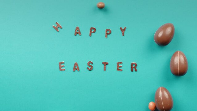 Easter chocolate eggs rolling on a yellow background