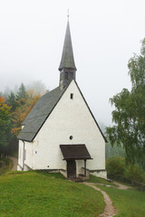 Fototapeta na wymiar Lonely chapel on a mountain shrouded in fog