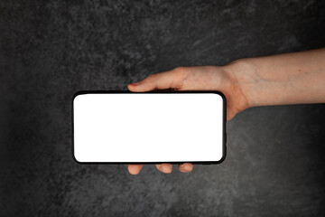 Smartphone in hand. White screen, dark background.