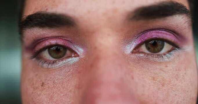 Close up of young transgender man with makeup looking on camera outdoor