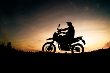Fototapeta na wymiar Men's silhouettes and touring motocross bikes. Park to relax in the mountains in the evening. adventure travel and leisure concept