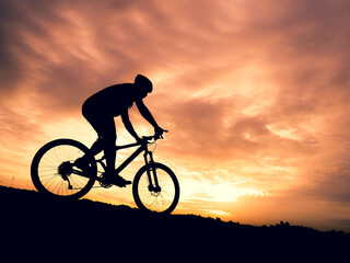 Silhouette of a male tourist and his bike, happiness and freedom. in the evening the light is beautiful