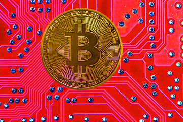 golden valueable single bitcoin from crypto currency with a light red board in the back