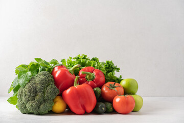 Healthy vegetables, fruits, green salad on the table. Grocery set of broccoli, lettuce, sweet red pepper, tomatoes, cucumbers, apples, lemon. The concept of organic, fresh food, grocery delivery