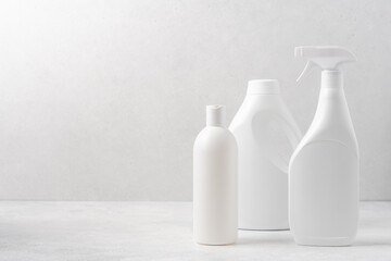 Set of white bottles with cleaning products on white background. Cleaning service concept
