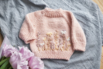 Knitted kids clothes and accessories for knitting. Needlework and knitting. Hobbies and creativity. Knit for children. Handmade. Hobbies and creativity. Sweater with embroidery