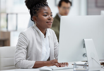 Finishing up her deadlines with determination. Shot of a young businesswoman working on a computer...