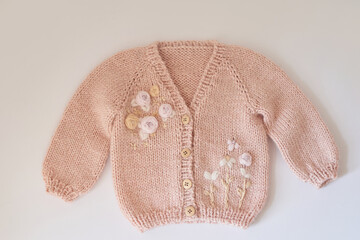 Knitted kids clothes and accessories for knitting. Needlework and knitting. Hobbies and creativity. Knit for children. Handmade. Hobbies and creativity. Sweater with embroidery