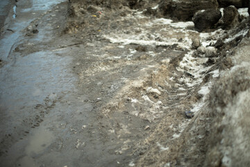 Dirty snow on side of road. Snow melts on asphalt. Situation on road after precipitation.