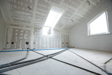 Attic finishing construction site in the phase drywall spackling and plastering before screeding