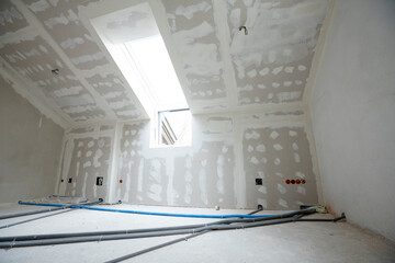 Attic finishing construction site in the phase drywall spackling and plastering before screeding