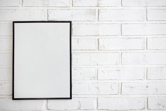 mock up poster frame over white brick wall background