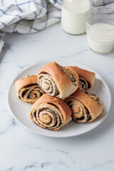 Sweet homemade poppy seed buns with milk for the breakfast