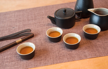 Cup and tea set with tea on table