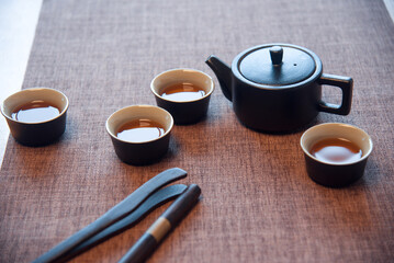 Cup and tea set with tea on table