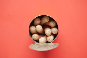 top view of sausage in a tin container on red background 