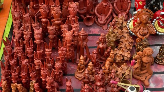 Terracotta items like clay horse, drum, madal, ganesh for sale in Burdwan, West Bengal, India. Brownish red clay is baked in urn to give Terracota finish.