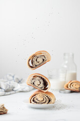 Flying homemade poppy seed buns with milk for the breakfast
