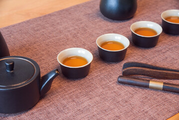 Cup and tea set with tea on table