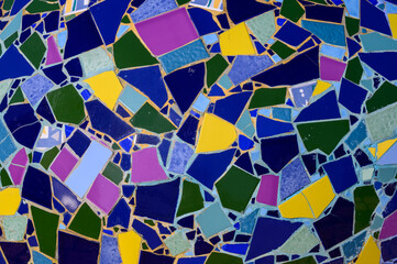 Wall decoration with ceramic mosaics of bright colors and unequal sizes.