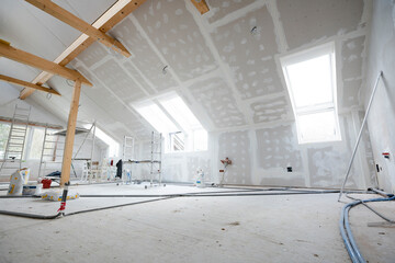 Attic finishing construction site in the phase drywall spackling and plastering before screeding