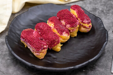 Raspberry eclair cake on dark background. World cuisine delicacies. close up