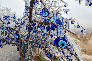 Blue evil eye ;nazar boncugu, turkish symbols hanging on a tree. cappadocia