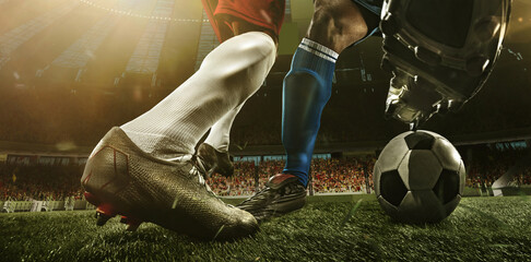 Close-up legs of soccer, football players in action, motion at the stadium with flashlights and...