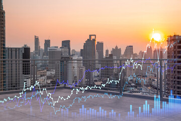 Obraz premium Rooftop with concrete terrace, Bangkok sunset skyline. Forecasting and business modeling of financial markets hologram digital charts. City downtown. Double exposure.