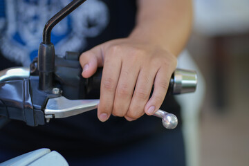 Closeup boy clutching motorcycle brake for safety