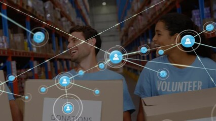 Animation of network of connections with icons over diverse volunteers in warehouse - Powered by Adobe