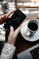 The girl analyzes the stock exchange, studying finance and economics over a cup of coffee, financial literacy and trading in the modern world