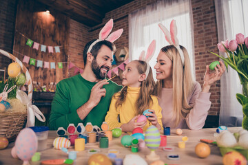 Portrait of positive friendly three people prepare easter eggs paint nose enjoy weekend together indoors