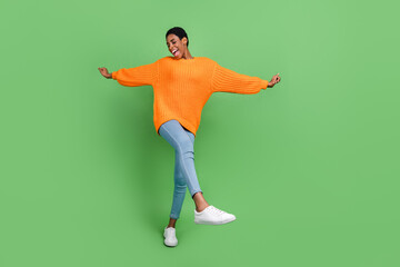 Fototapeta na wymiar Full body photo of cute millennial brunette lady dance wear sweater jeans sneakers isolated on green background