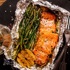 Baked in foil salmon with vegetables and sauce. menu concept.
