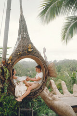 Couple sitting in a large nest on a Bali