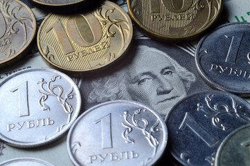 the American dollar on top of which are Russian coins of 1 ruble and 10 rubles. translation of the inscriptions on the coins: 